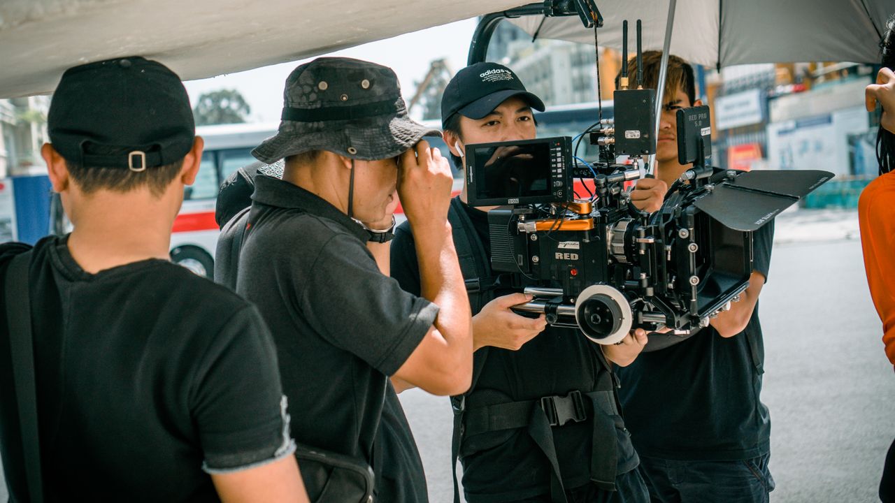 A group of filmmakers using professional camera equipment on an outdoor set.
